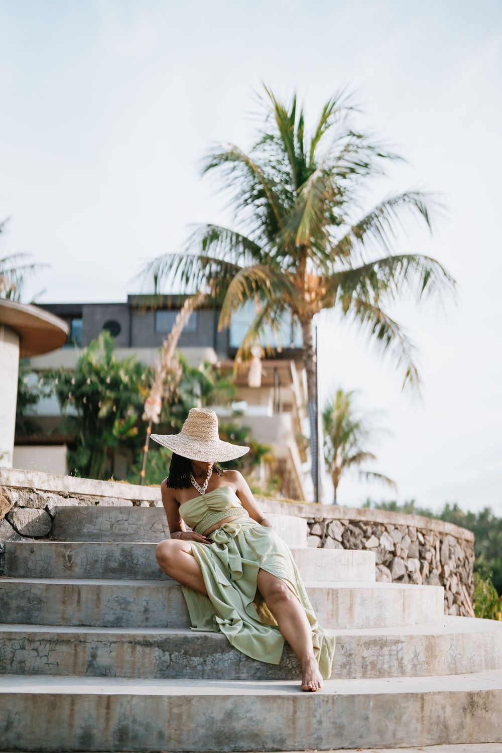 Stone steps with palm trees and tropical landscaping in resort setting.