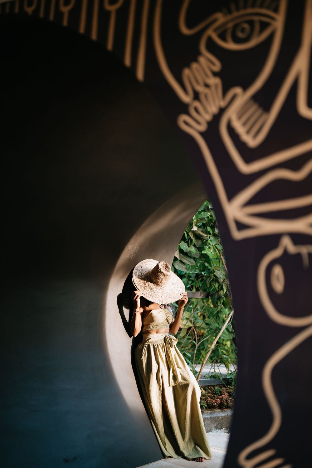 Decorative circular window frame with artistic cutouts overlooking tropical garden.