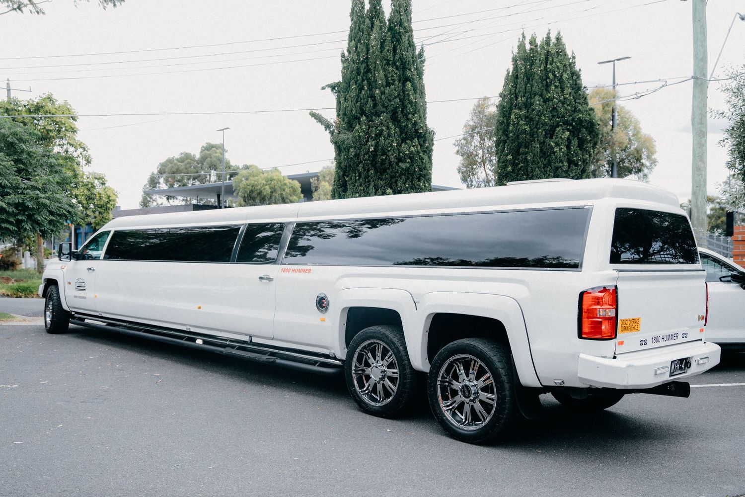 A long white stretch limo displays varying angles showcasing its elegant extended profile and pristine condition.