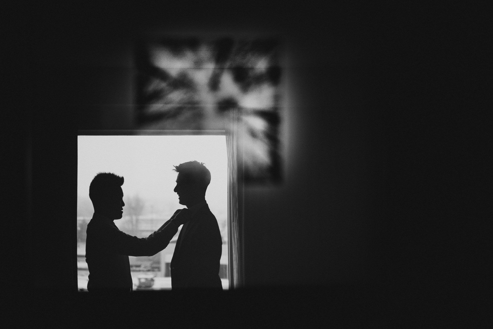 Artistic black and white silhouettes of figures against window backlight.