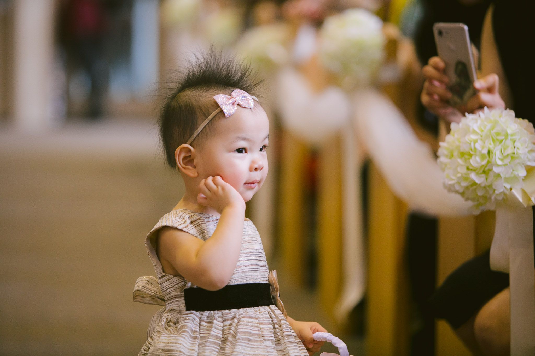 Young child in formal attire at an elegant wedding reception venue.