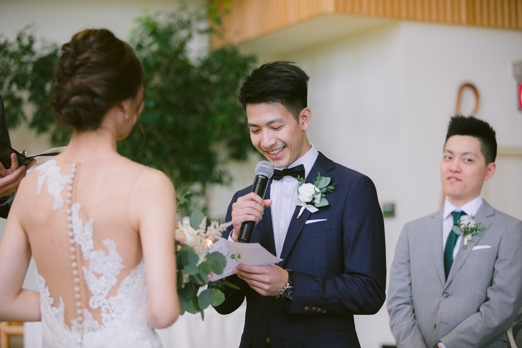 Outdoor wedding ceremony with natural greenery backdrop and formal attire.