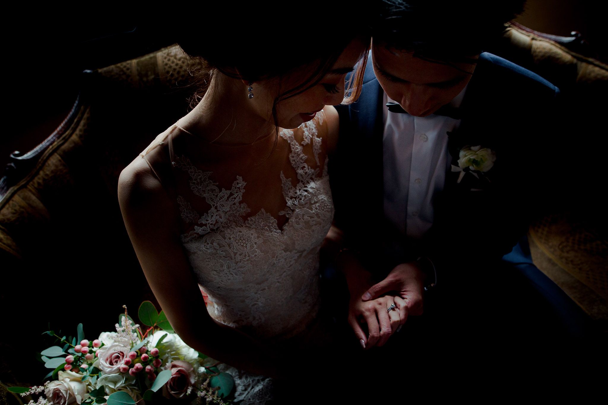 Dramatic low-light wedding photography captures intimate moments during the ceremony.