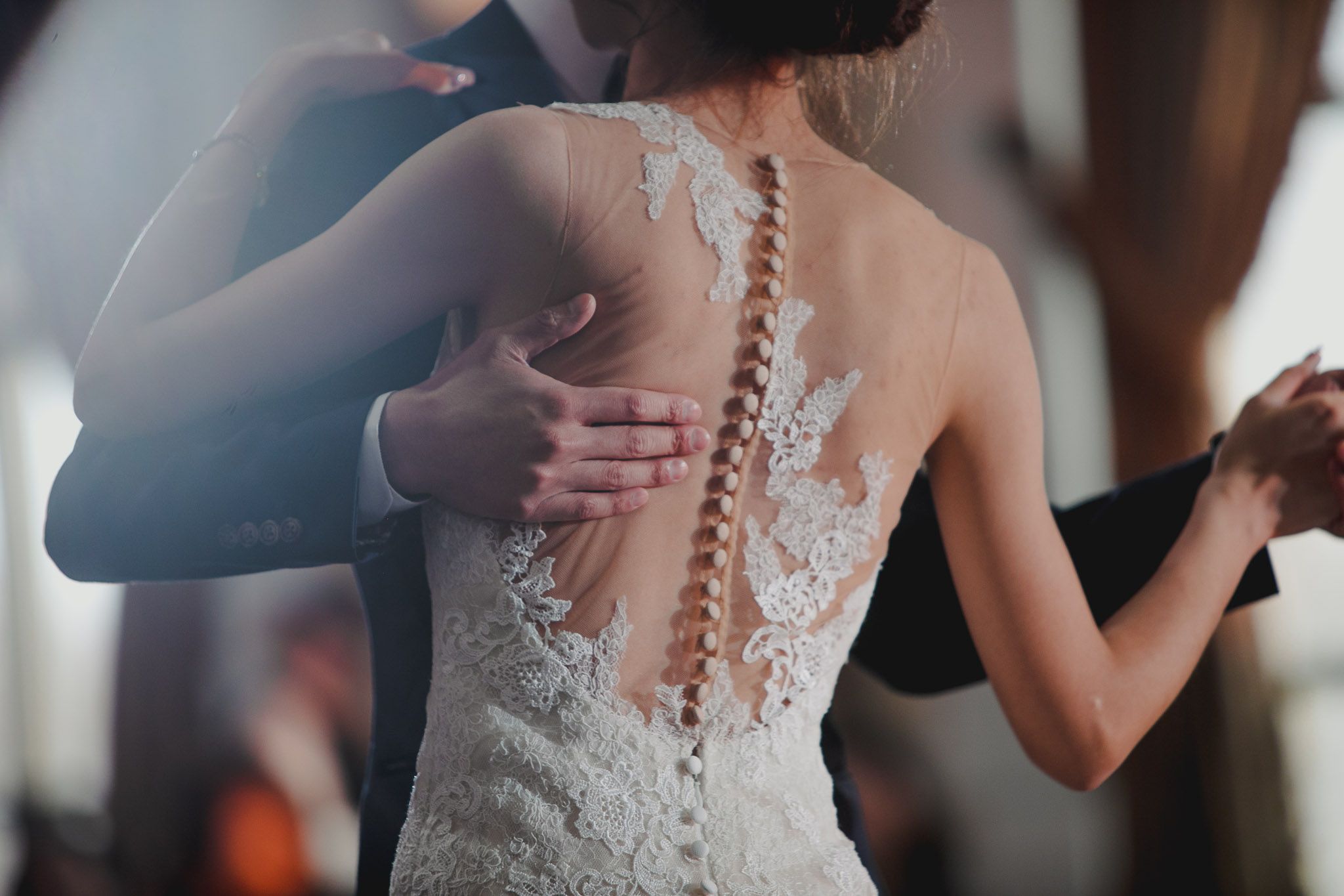 Elegant lace wedding dress details shown in a series of close-up shots highlighting intricate back designs.