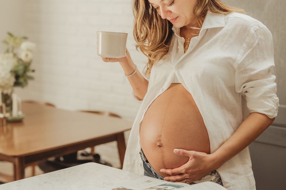 Candid maternity photos capturing tender moments in a bright home setting.