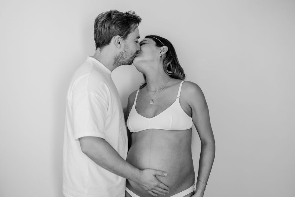 Black and white intimate maternity portraits with soft lighting.
