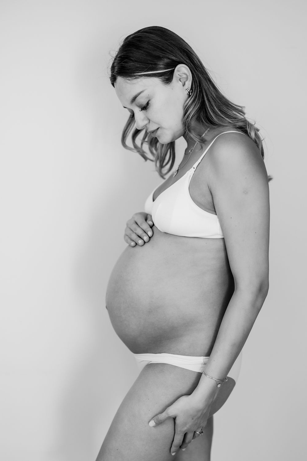 Artistic black and white maternity photos showing a pregnant belly.