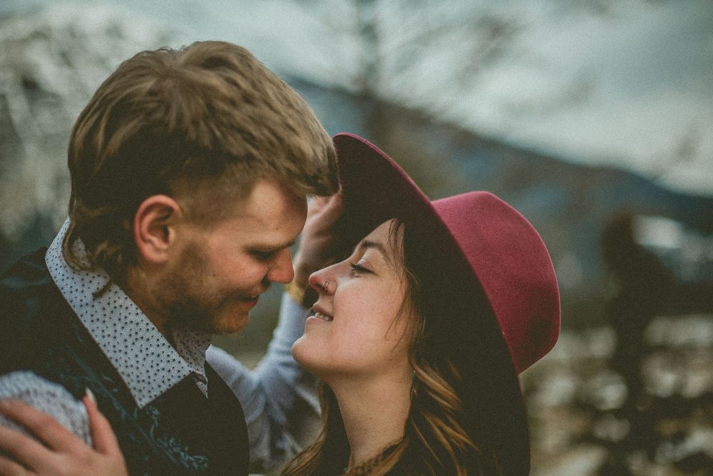 A couple shares intimate moments in a series of romantic outdoor photos against a blurred natural background. Jasper Engagement Photographer