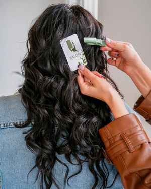 Styling dark curly hair with hair clips in a step-by-step process.