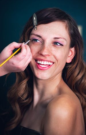 Playful beauty photoshoot with dramatic lighting and bright red lipstick.