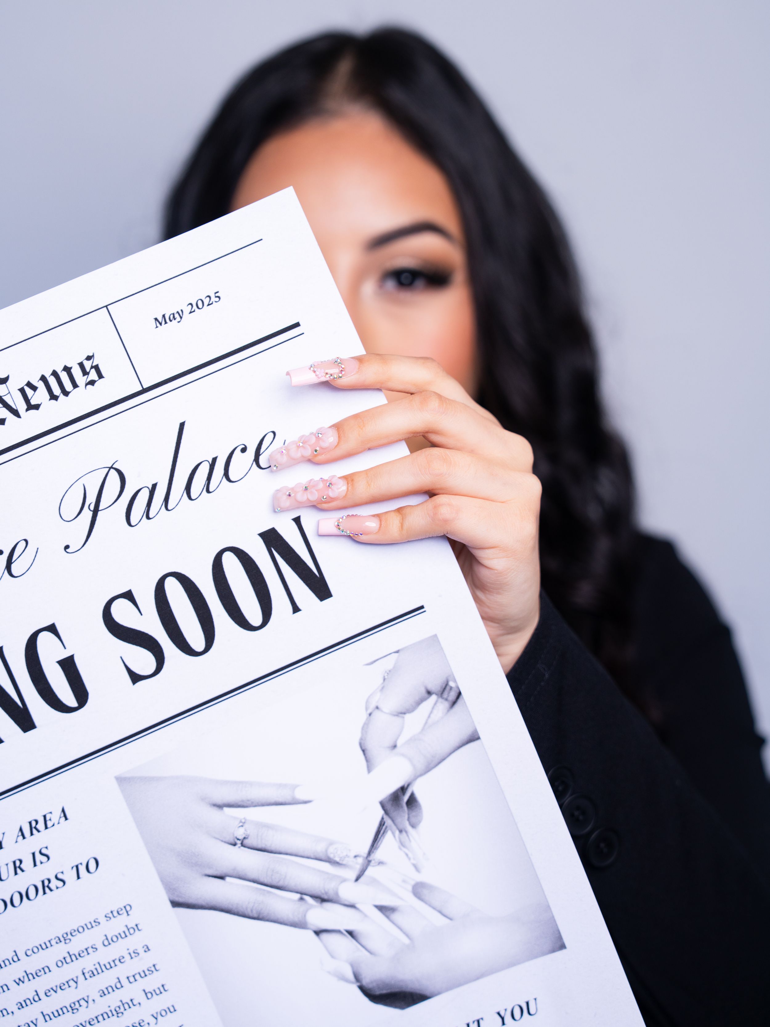 Close-up of hands holding a black and white newspaper announcement.