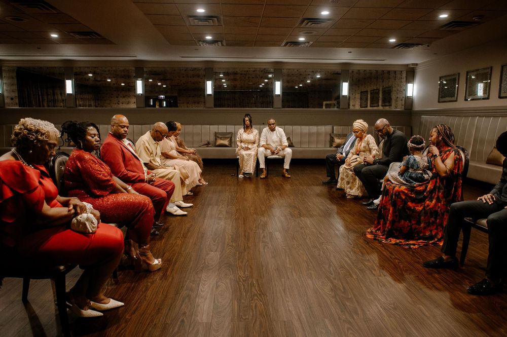 Students participate in an indoor exercise class while sitting on floor mats in a spacious studio.