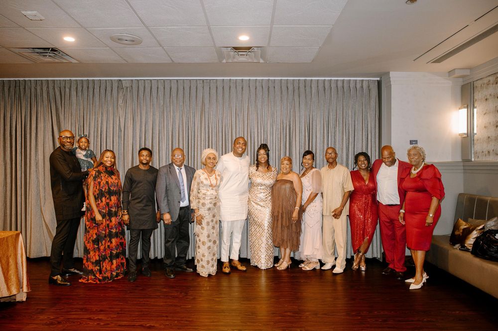 A panoramic group photo showing people dressed in white and red standing together in a bright indoor space.