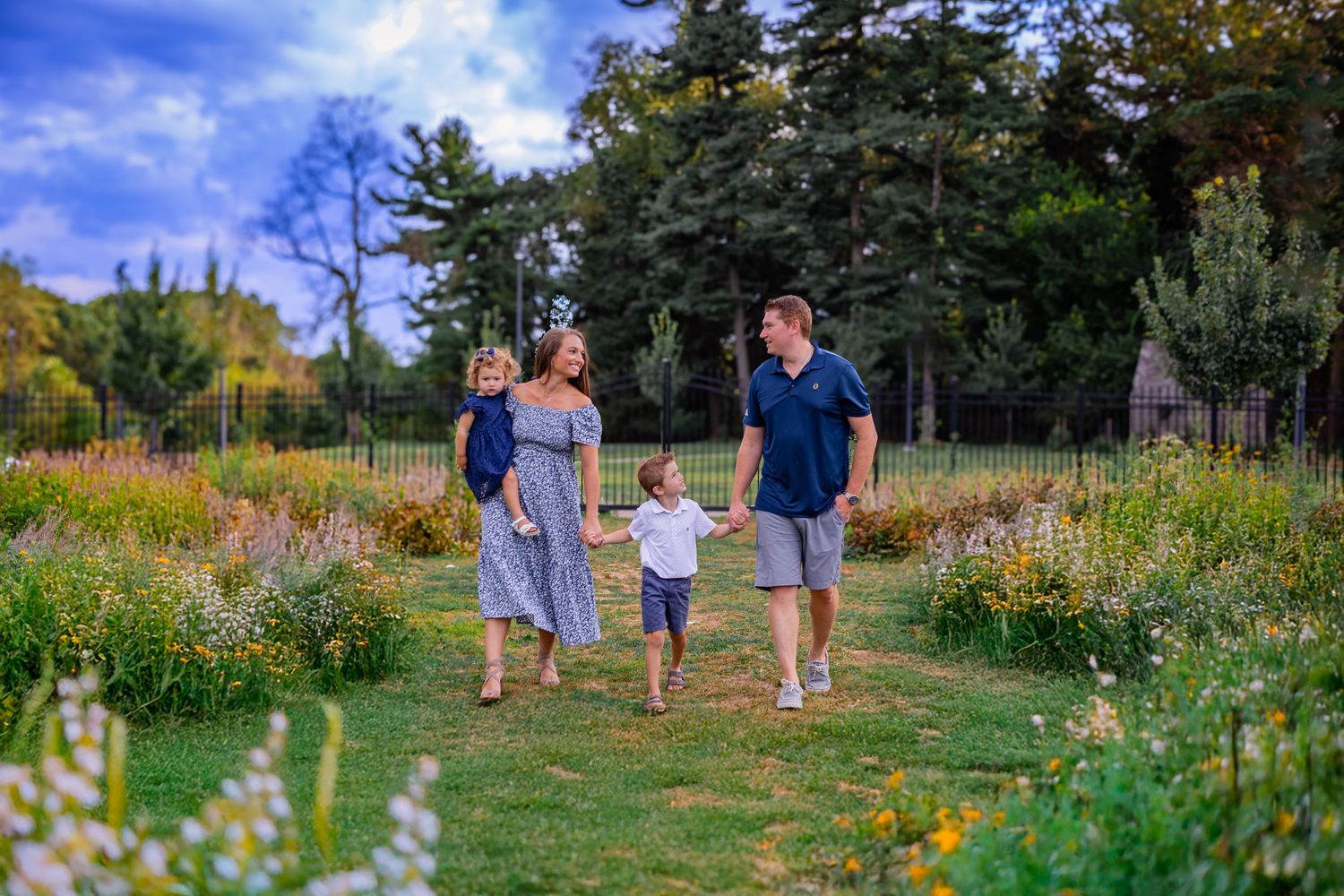 A family shares smiles and sweetness walking in a field of flowers