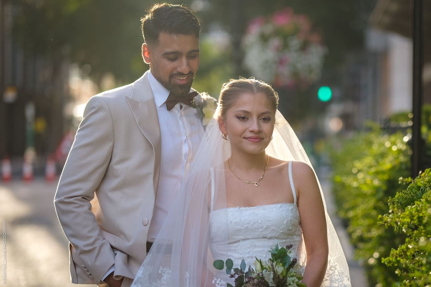 Happy couple shares tender moments in outdoor garden wedding photoshoot with soft natural lighting.