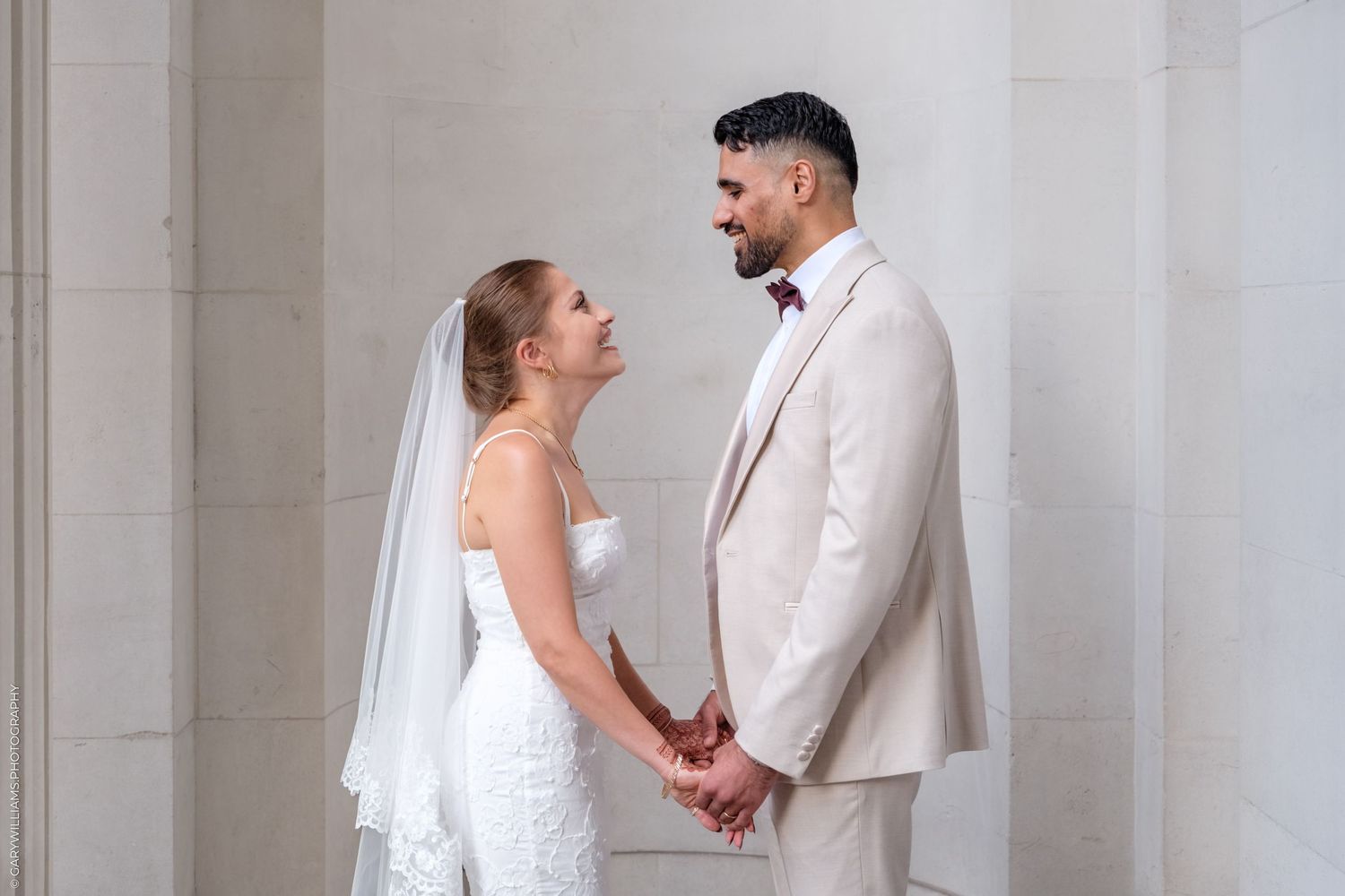 A bride and groom share romantic moments in a series of elegant white marble wedding portraits.