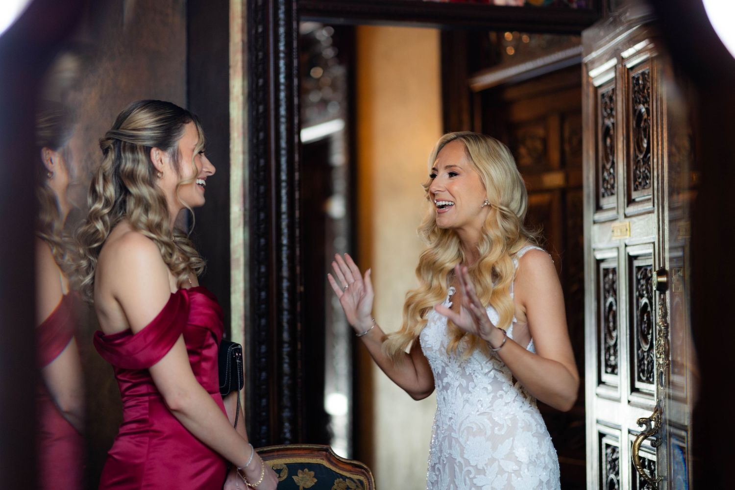 An elegant scene shows people near a decorative mirror in formal wedding attire.