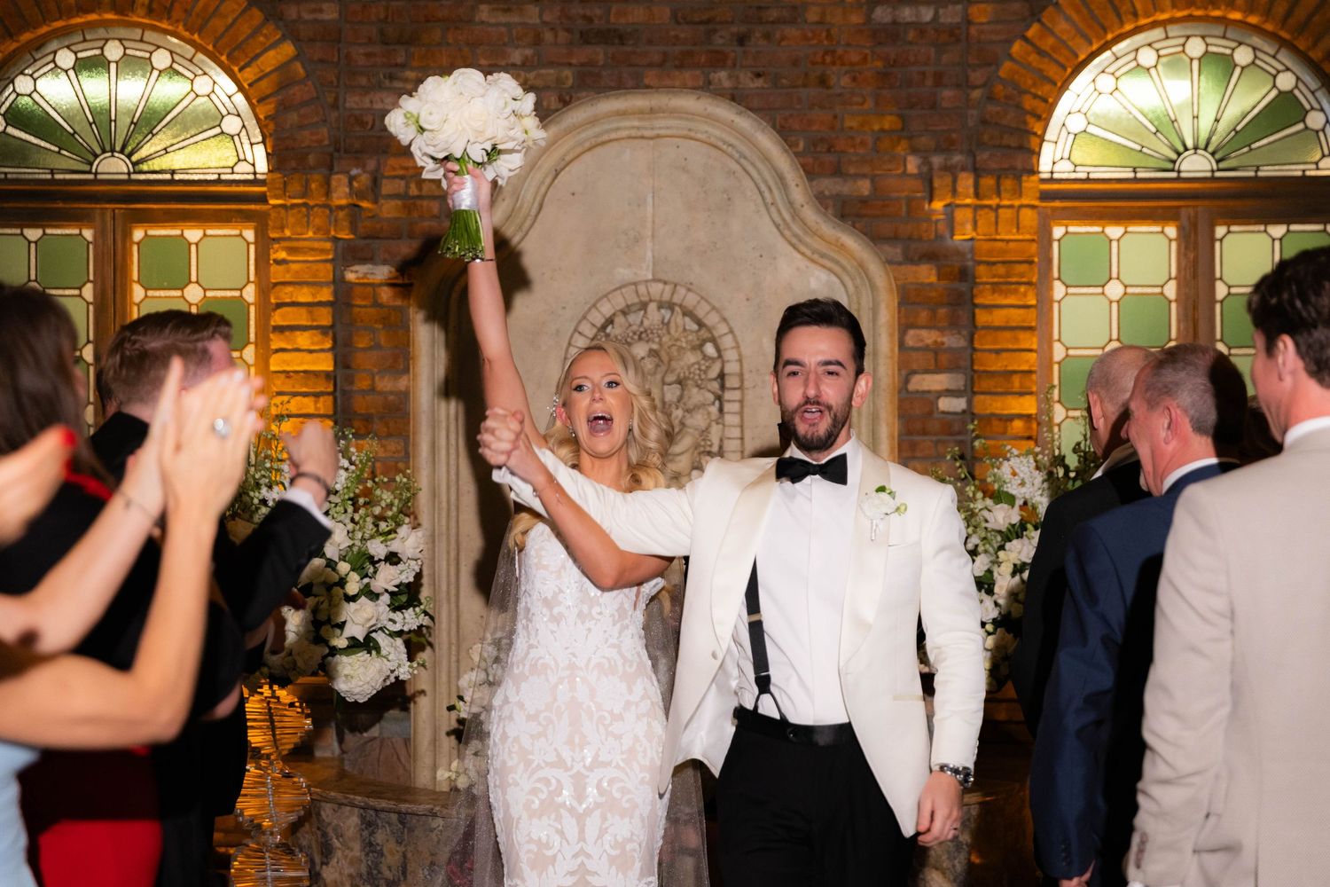 Wedding reception celebration in atmospheric brick venue with warm lighting.