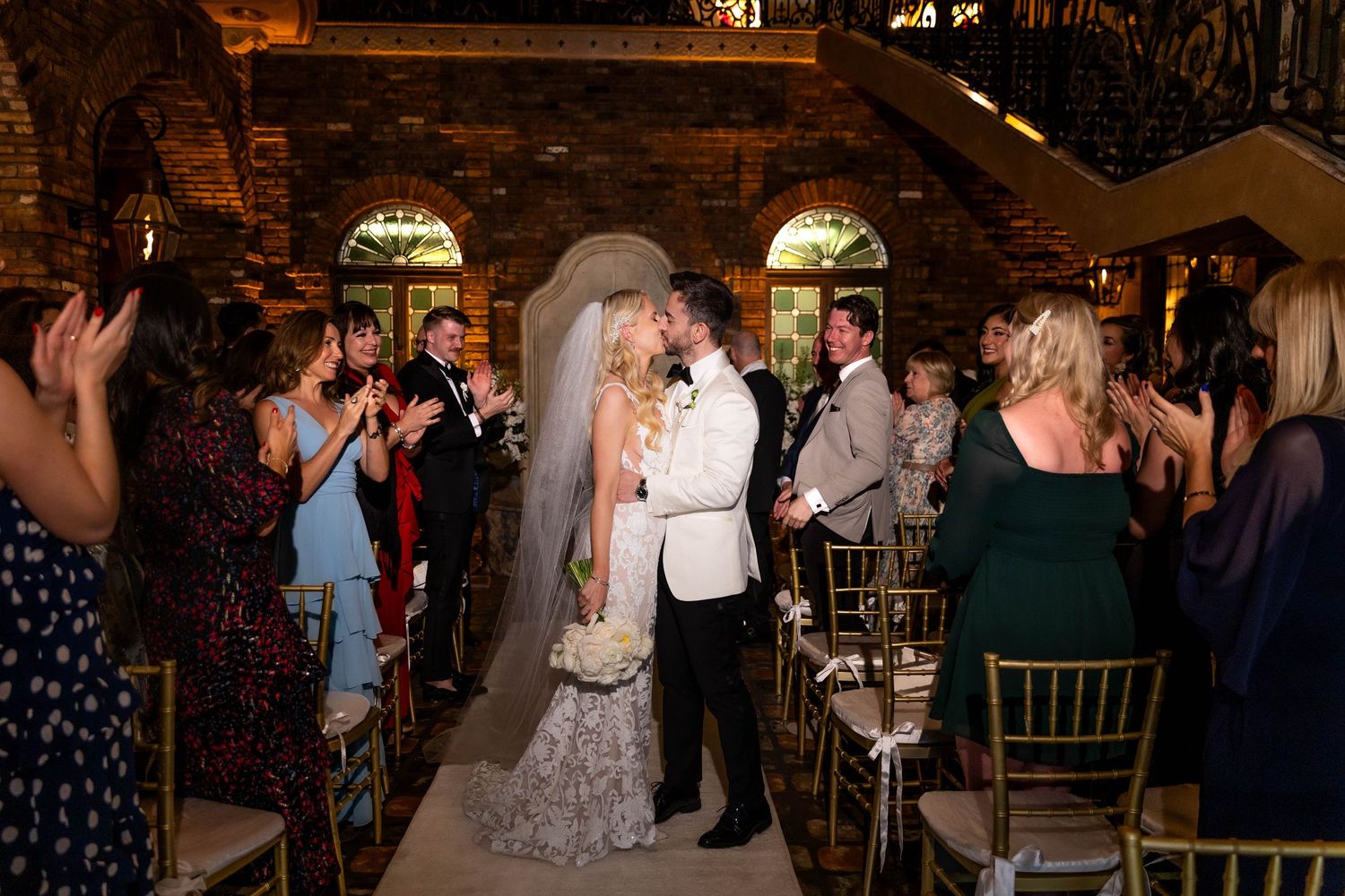 Evening wedding reception in a rustic brick venue with ambient lighting.