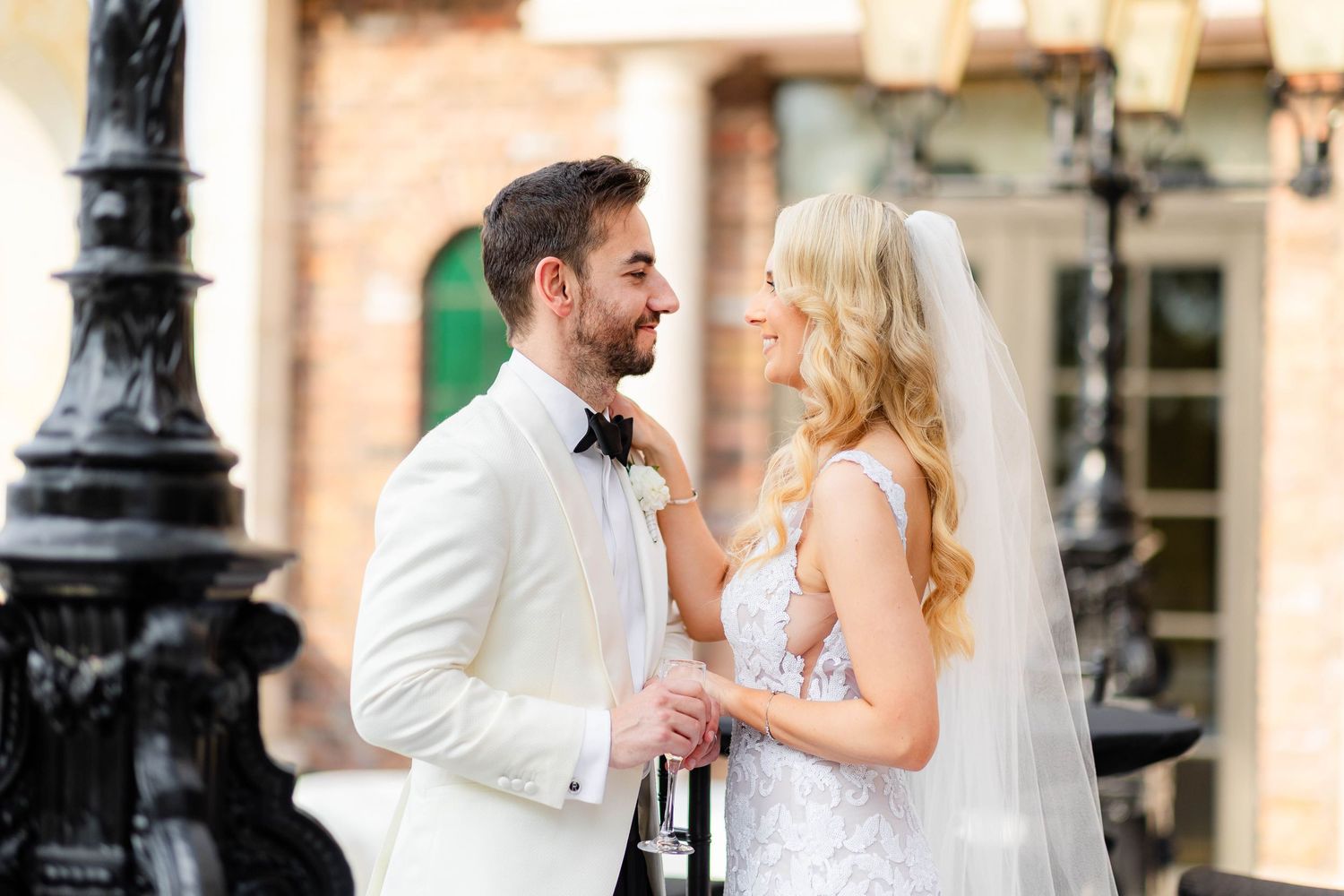 Wedding couple shares romantic moment on outdoor terrace with historic architecture.