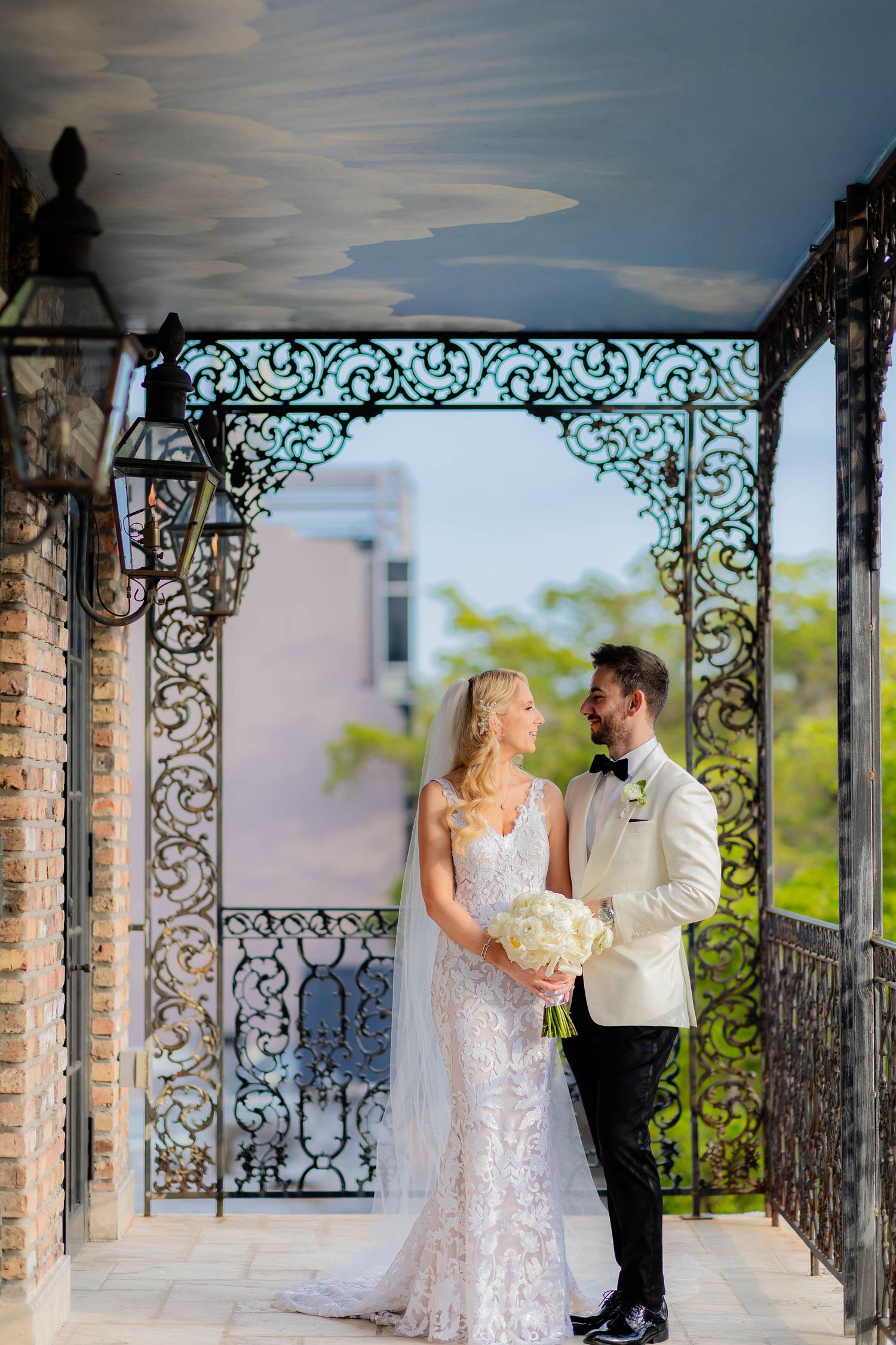 Romantic wedding portraits captured under an ornate wrought iron pergola.