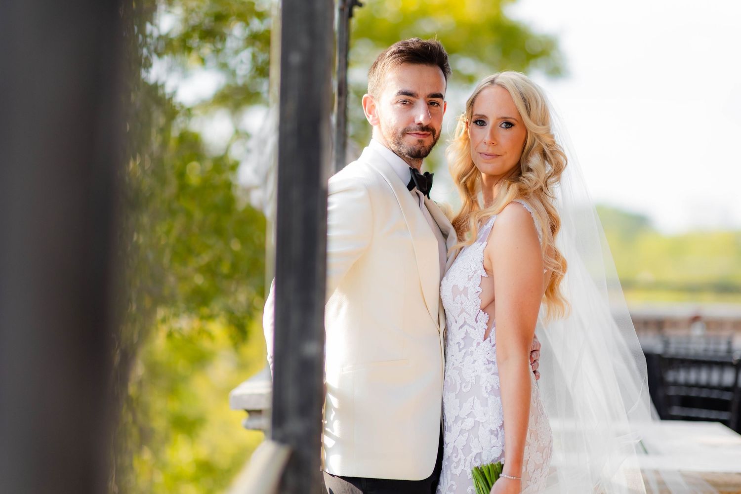 Outdoor wedding photoshoot with elegant white dress and formal attire.