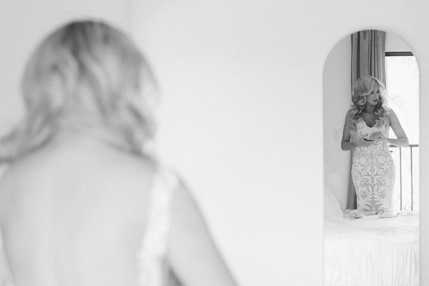 Ethereal white bridal preparation scene with soft natural window light.
