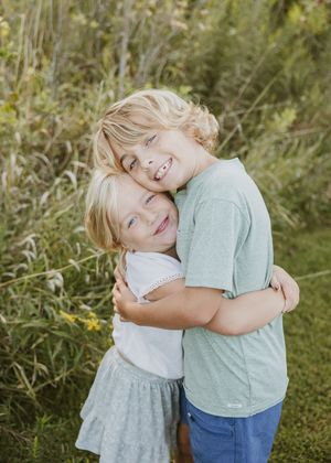 Candid moments of playful hugs and laughter in a natural outdoor setting.