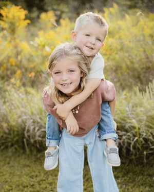 Playful piggyback rides shared between family members in casual outdoor setting.