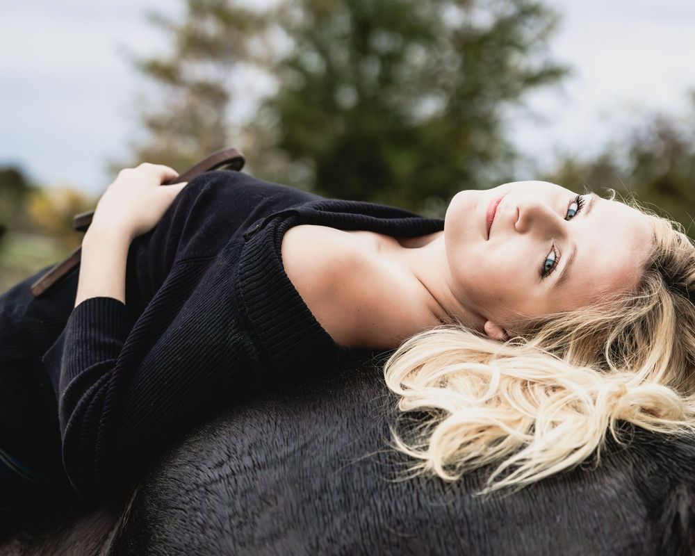 A series of artistic black and white portraits showing a person with blonde hair against dark backgrounds.