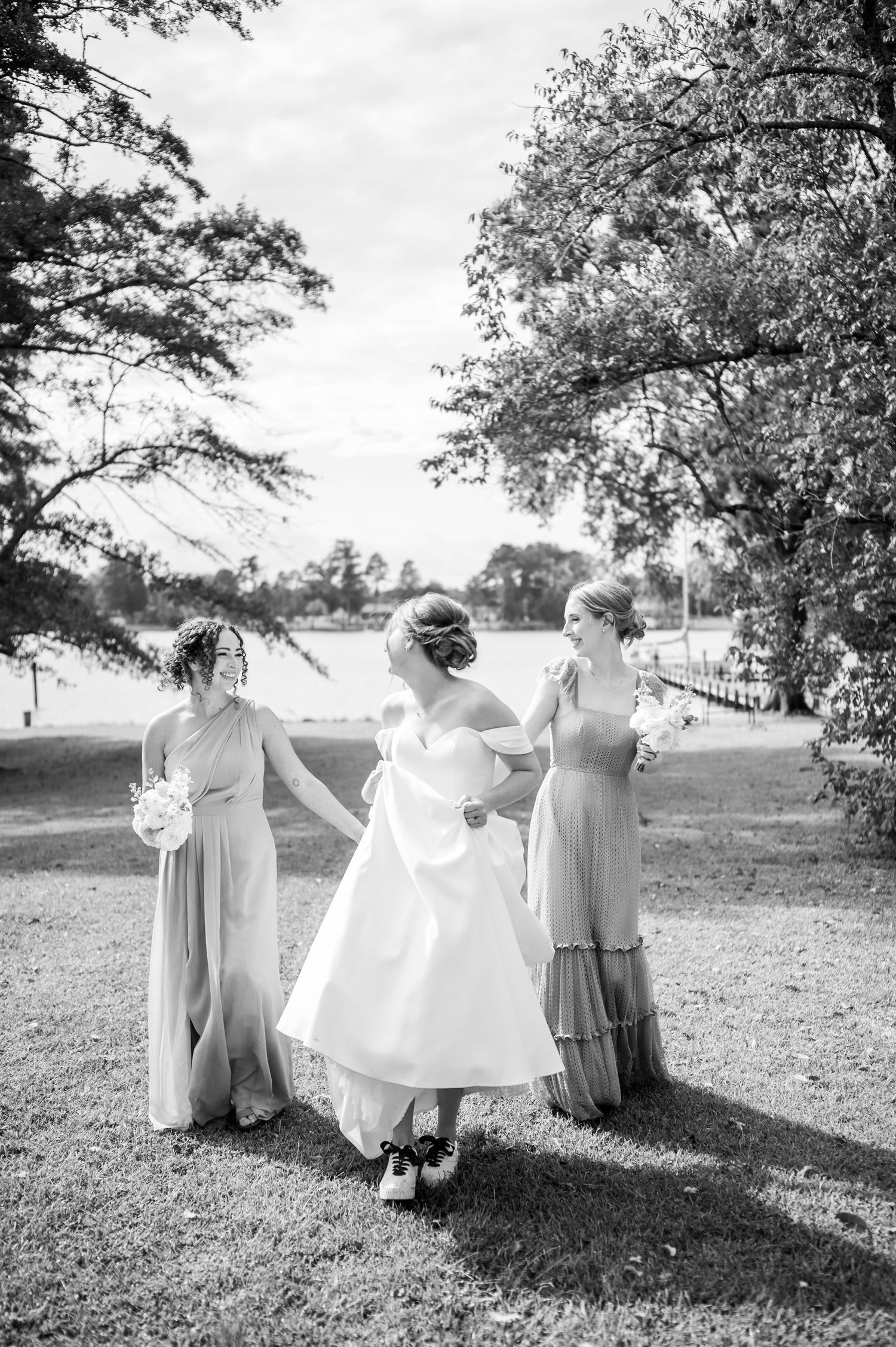 Black and white photo of wedding guests dancing and celebrating on a dance floor at a reception celebration.