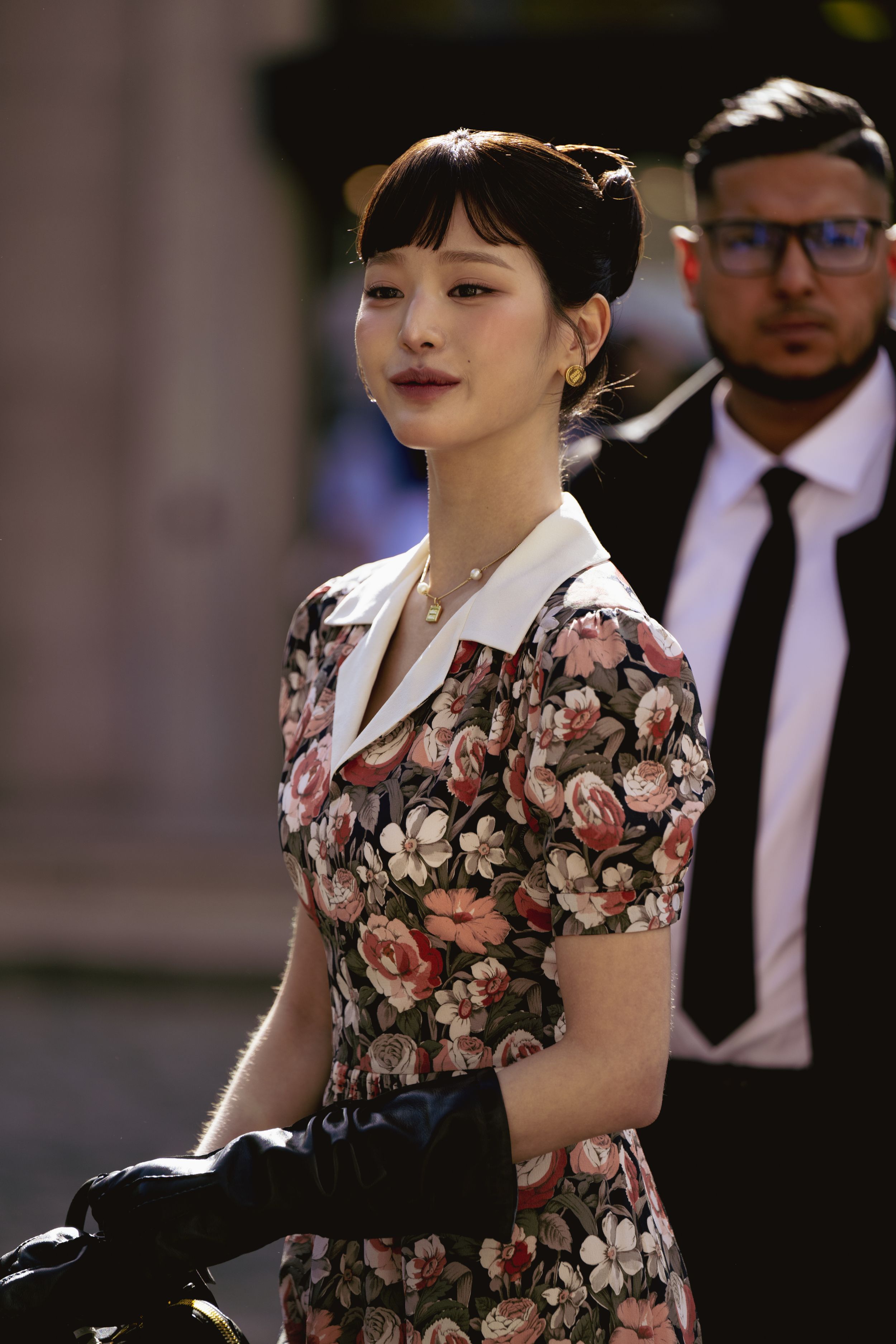 Vintage-inspired floral dress with white collar and black gloves in an elegant daytime look.