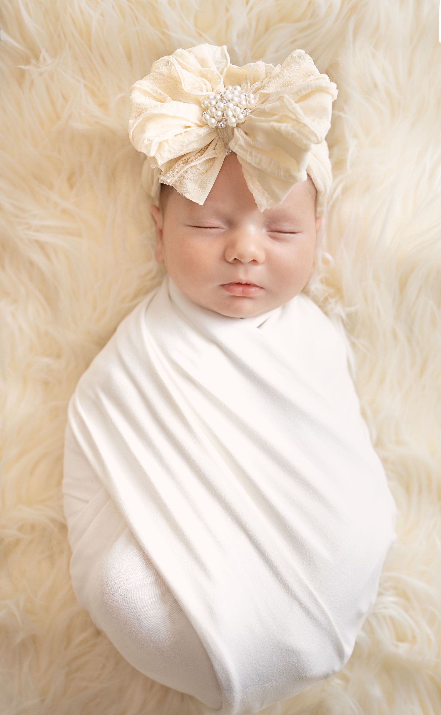 Newborn baby wrapped in neutral blanket during in-home studio session in San Diego