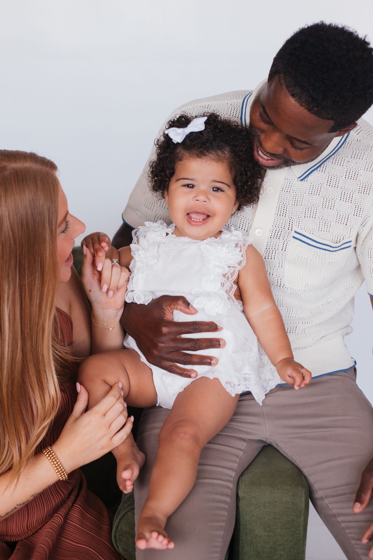 Happy interracial family sharing joyful moment with their baby daughter.