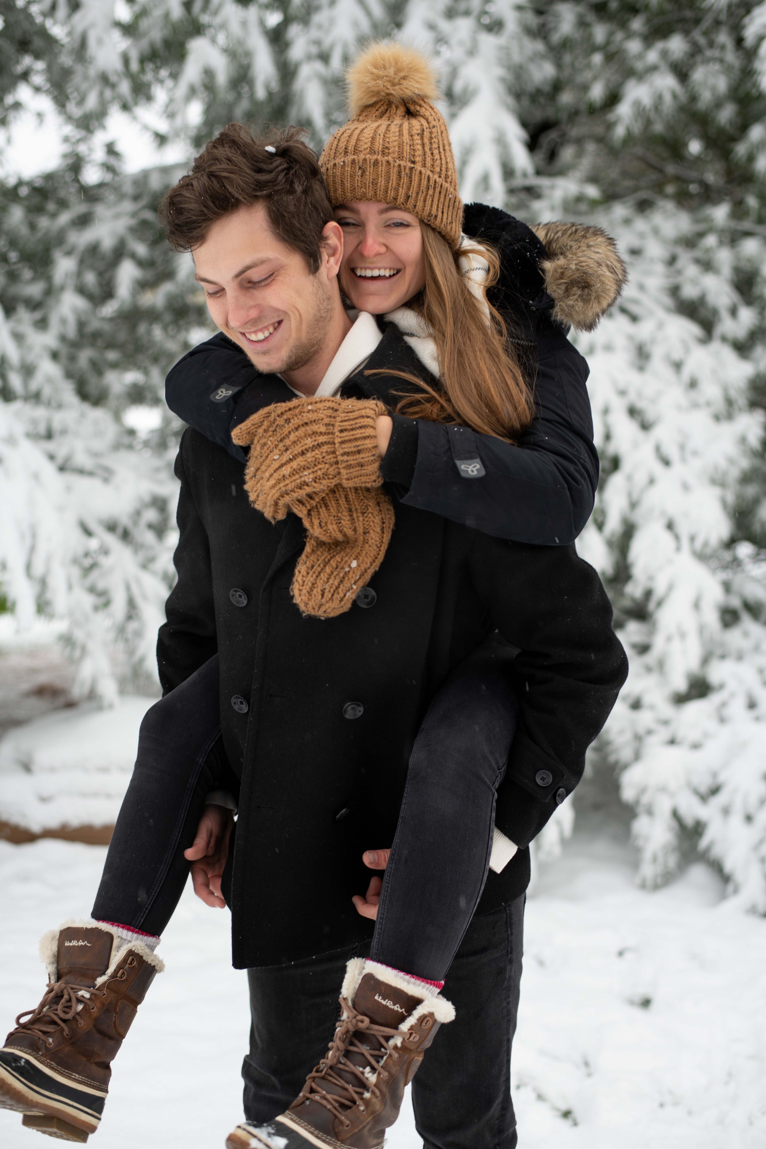 A playful winter scene showing a piggyback ride in the snow with cozy winter attire including mittens and a knit hat.