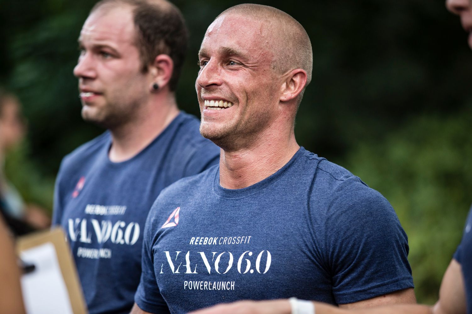 Athletes in blue performance t-shirts participating in outdoor fitness event.