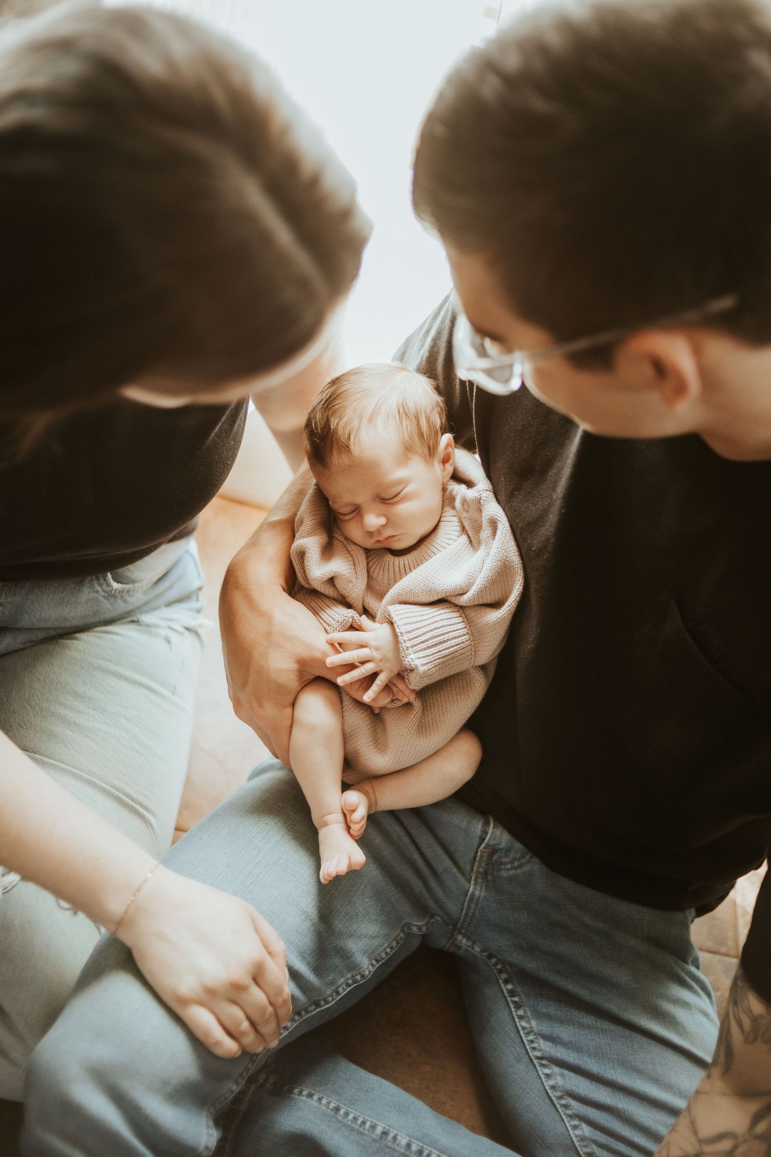 An intimate family moment with a sleeping baby held close.