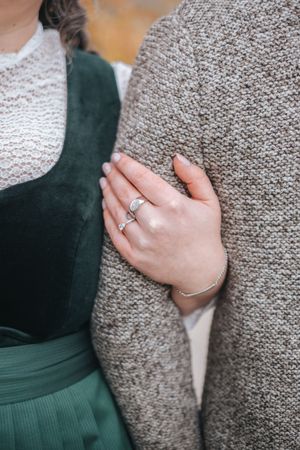 Hochzeitsfotografie: Detailaufnahme einer Hand mit Ehering, die sich an den Arm des Partners lehnt.