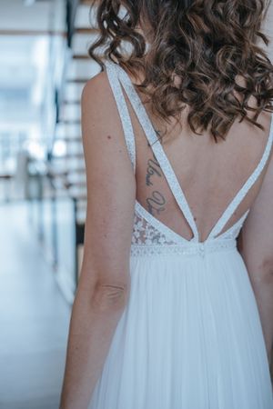 Hochzeitsfotografie: Rückansicht der Braut im fließenden Brautkleid, Detailaufnahme im Innenraum.
