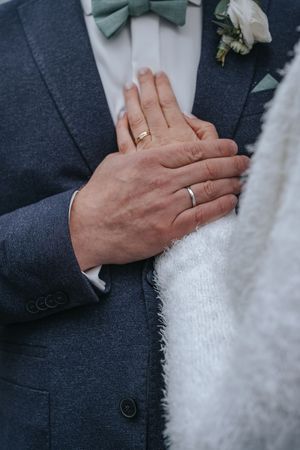 Hochzeitsfotografie: Nahaufnahme der Hände eines Brautpaares mit Eheringen, ruhiger Moment der Nähe.