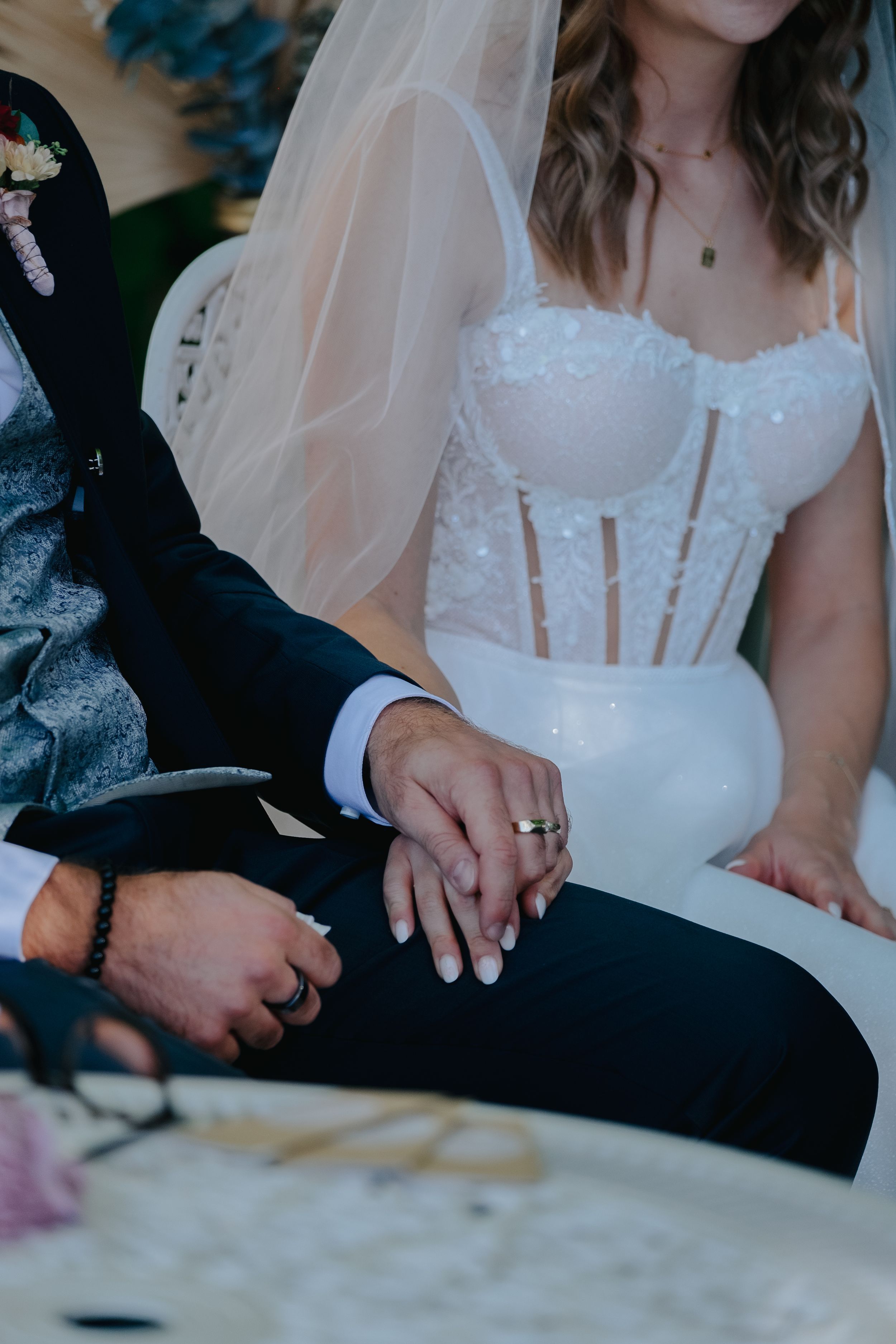 Hochzeitsfotografie Pfaffenhofen a.d. Ilm: Detailaufnahme der Hände eines Brautpaares während der Trauung, die Braut trägt ein Spitzenkleid.