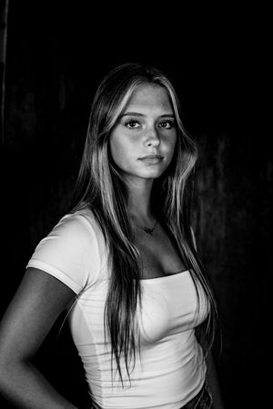 Black and white portrait series showing a person in a white t-shirt posing against a dark background.
