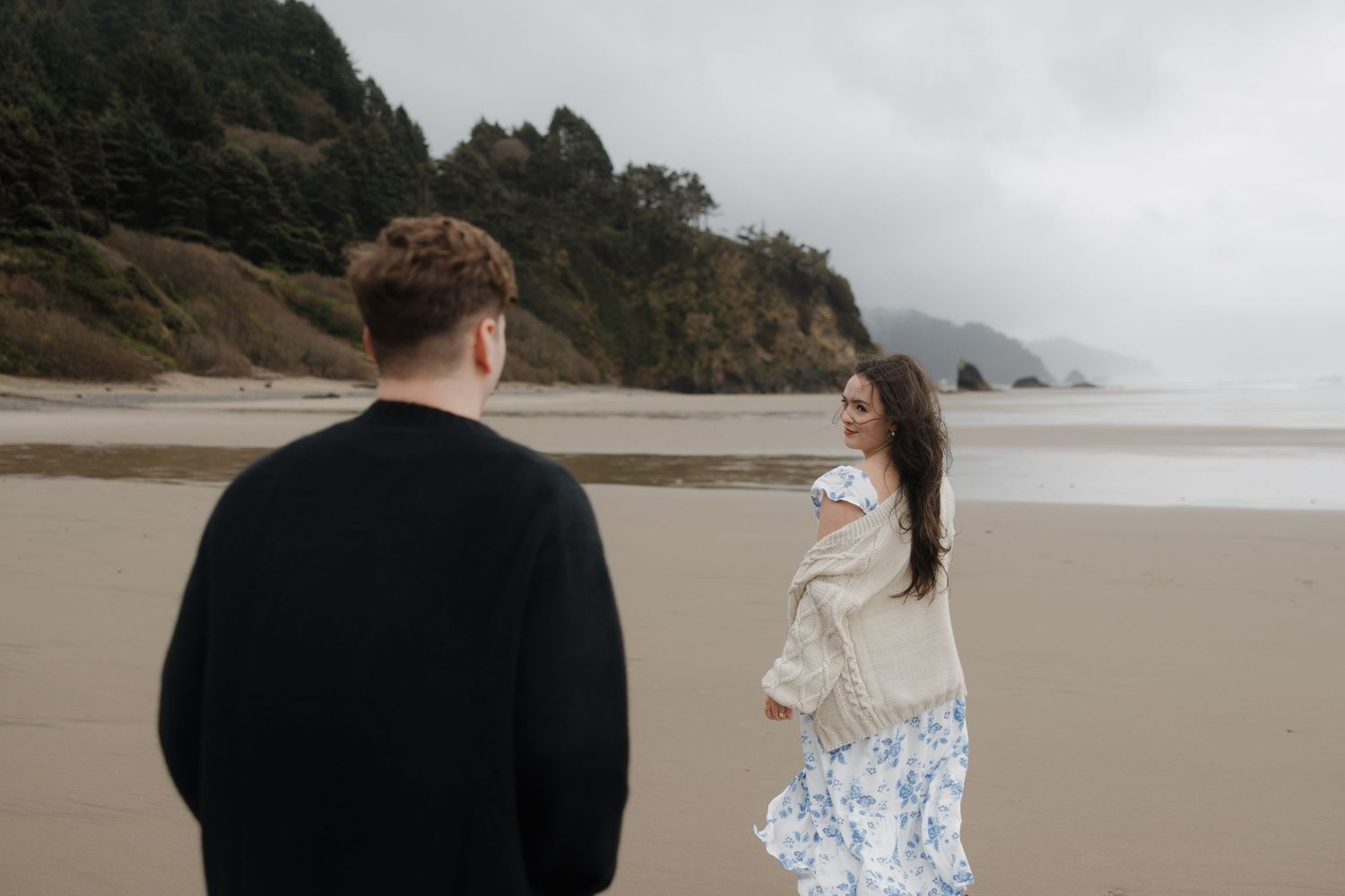 A romantic moment captured on a misty Pacific Northwest beach.