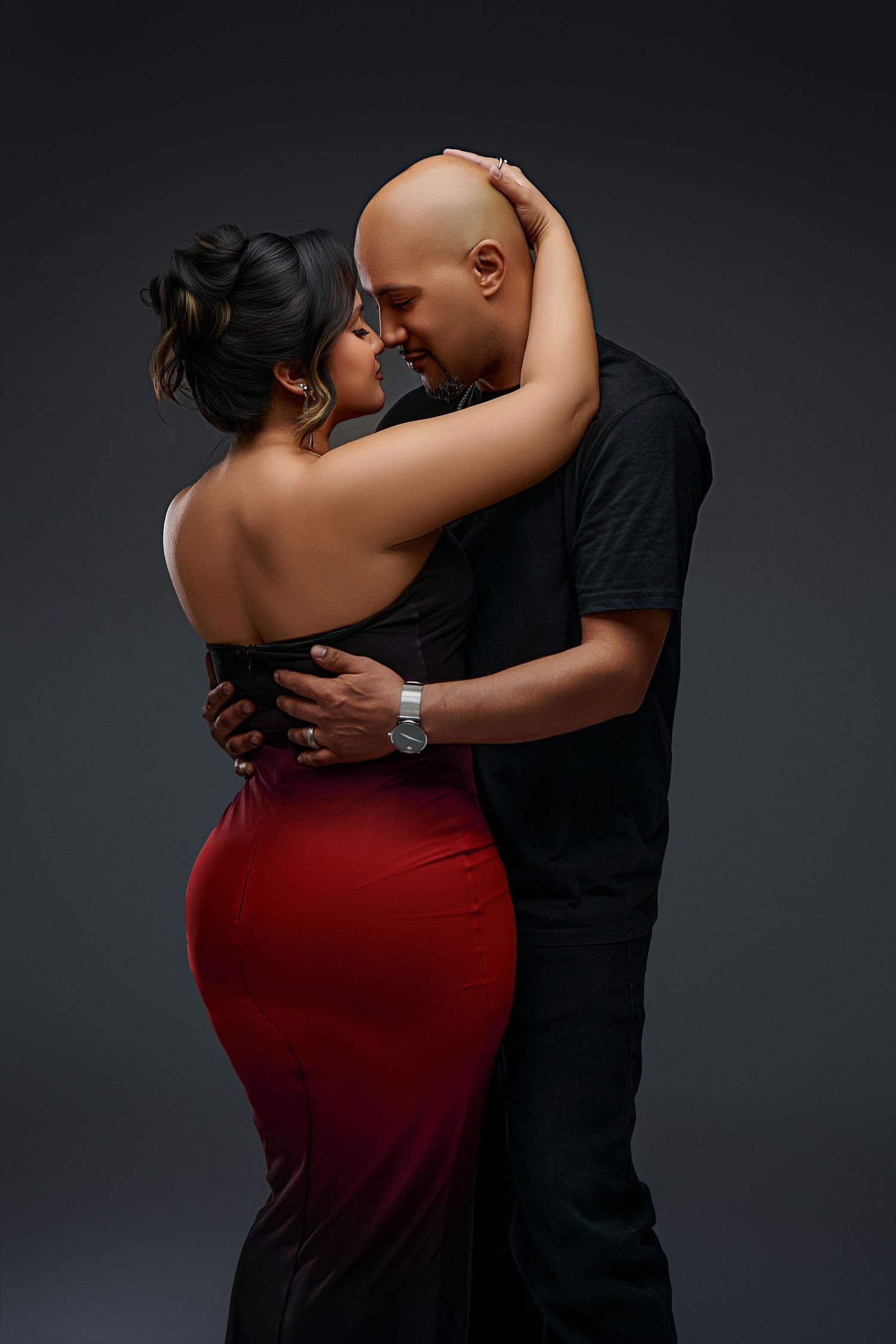A romantic dance pose features a couple embracing, with the woman wearing a red dress against a dark studio backdrop.