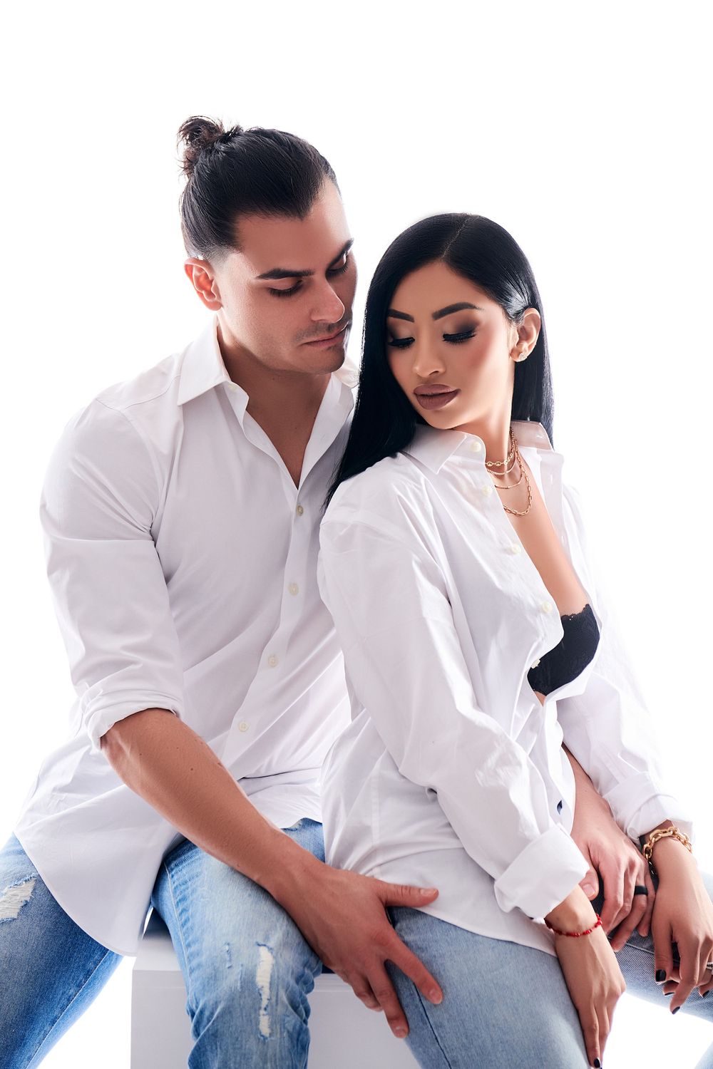 Two people wearing white shirts pose together for a romantic fashion photography session.