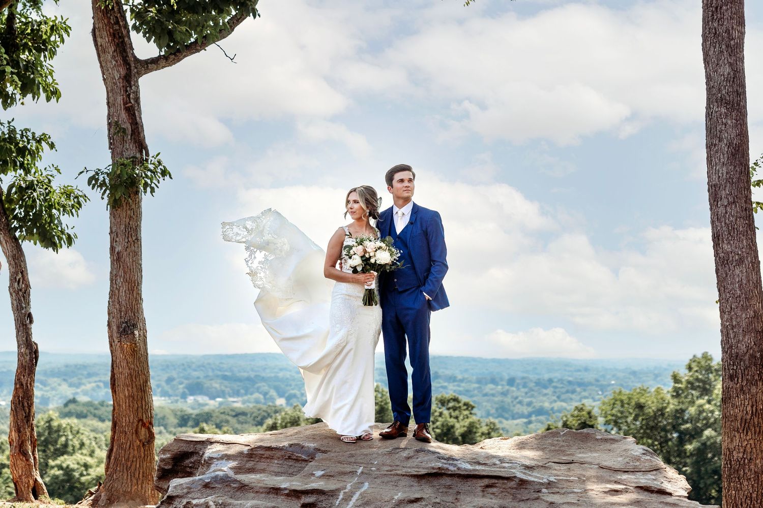 Bride and groom on wedding day atop a rock overlooking MIddle Tennessee.  Middle TN wedding photographer.