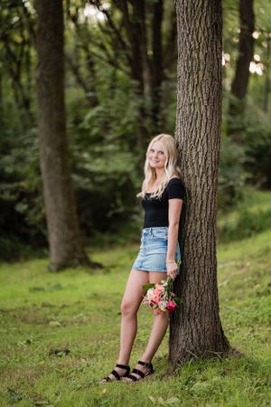 Summer portrait in woods with flowers and natural lighting creating soft romantic atmosphere.