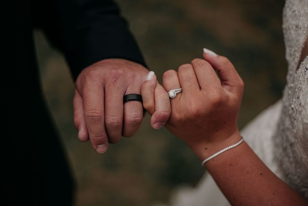 A close-up sequence of hands exchanging wedding rings during a marriage ceremony.