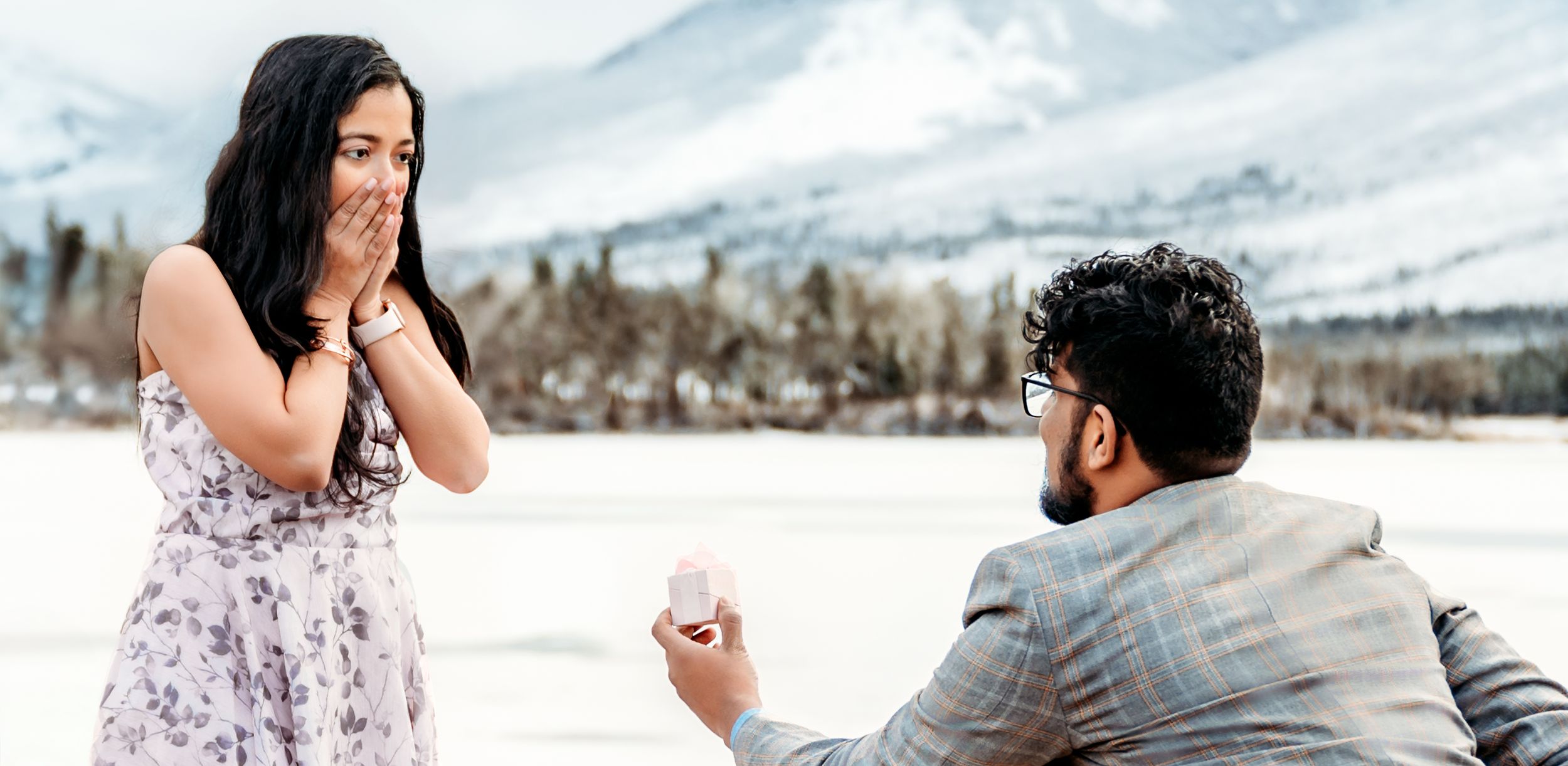 A surprise proposal moment captured in a winter mountain setting.