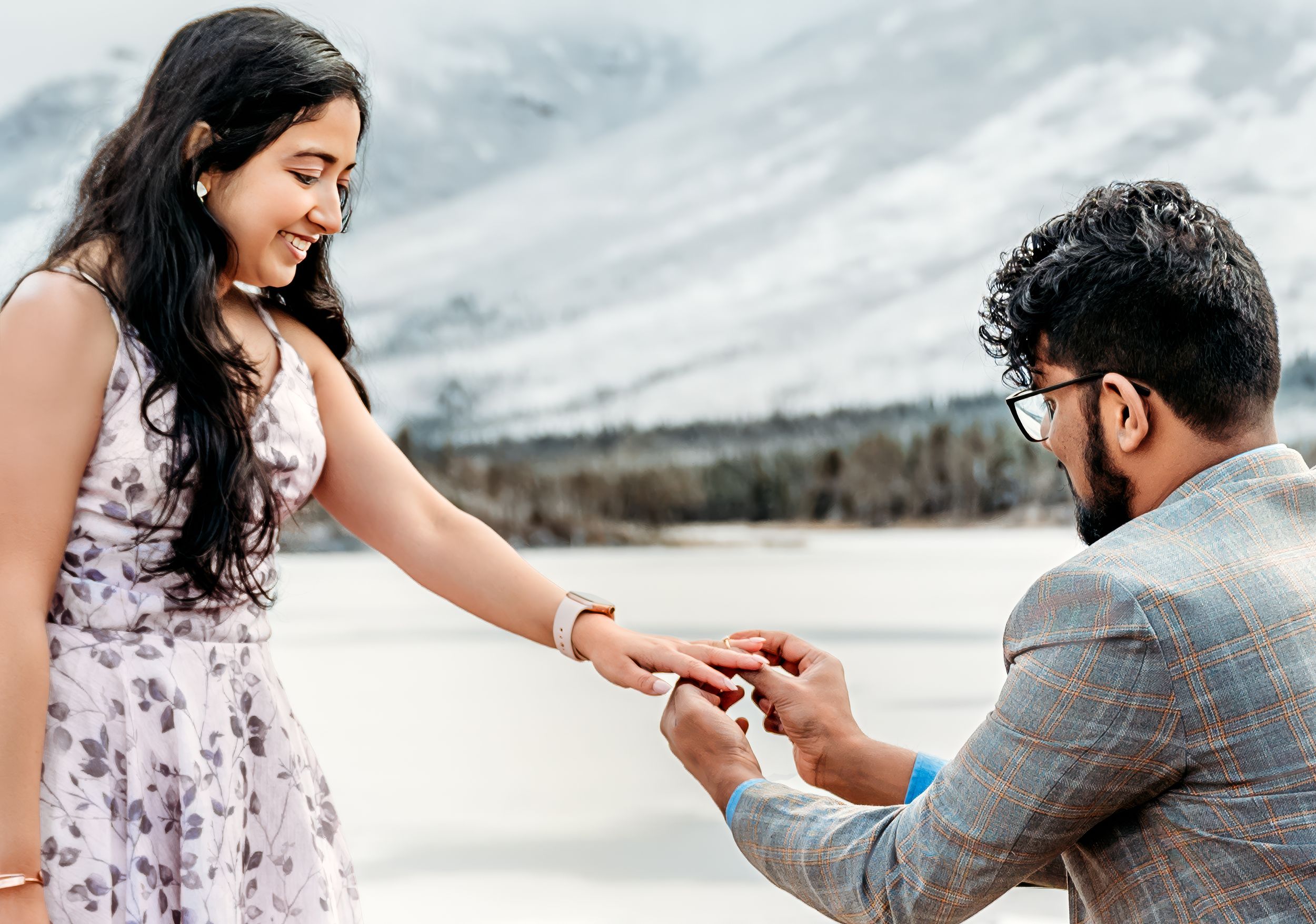 A proposal scene with snow-capped mountains in the background.